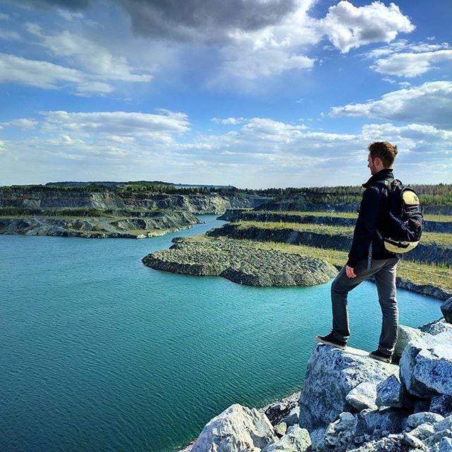 water, lifestyles, leisure activity, casual clothing, sky, tranquility, tranquil scene, scenics, full length, beauty in nature, rock - object, nature, standing, rear view, vacations, cloud - sky, men, young adult