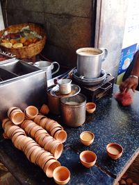 High angle view of cups and tea in container at stall