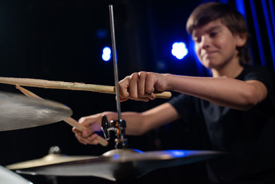 Midsection of man playing drum