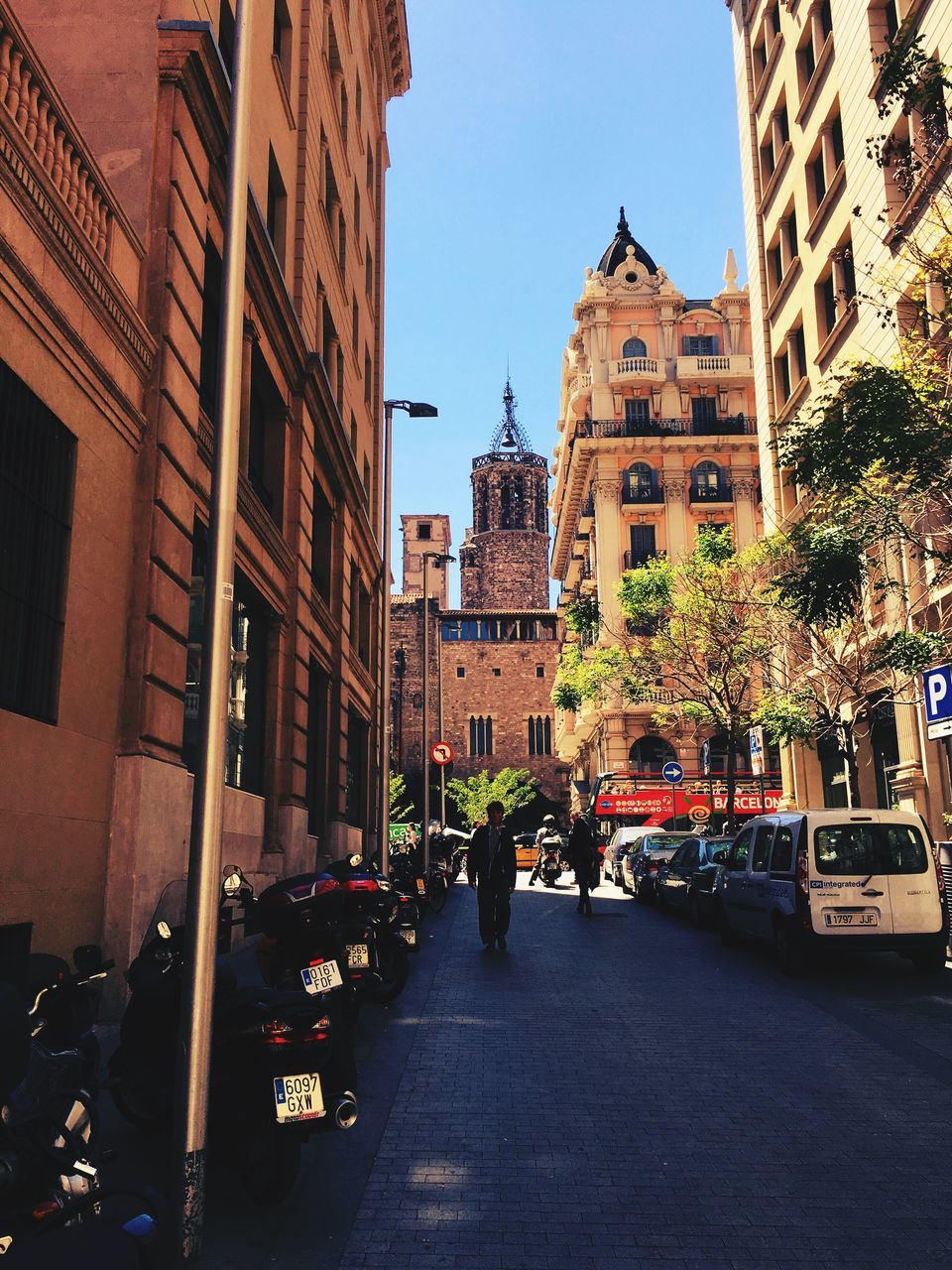 building exterior, architecture, built structure, city, street, transportation, the way forward, car, clear sky, land vehicle, city life, men, mode of transport, bicycle, incidental people, diminishing perspective, building, city street, walking