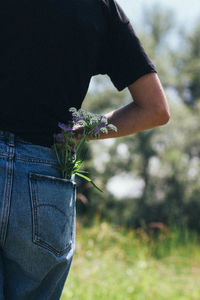 Close-up of person holding red flowering plant