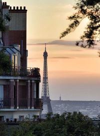 Tower in city at sunset