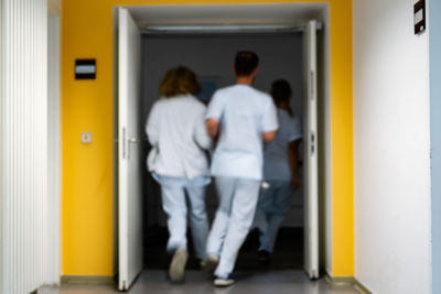 Rear view of people walking in corridor