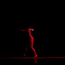 Midsection of woman standing against black background