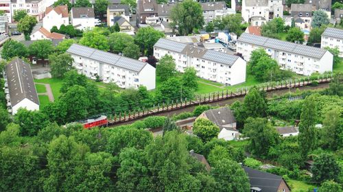 High angle view of railroad track surrounded by trees in city