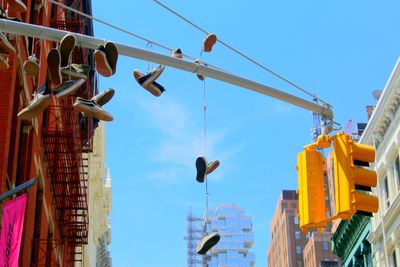 Low angle view of shoes tied on road signal in city