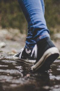 Low section of person wearing canvas shoes standing outdoors