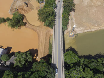 River flooding due to rain causes large mud next to a dam that prevents the rivers from meeting 