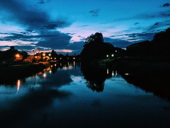 Reflection of silhouette trees in calm lake
