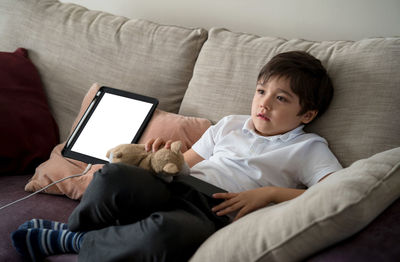 Boy sitting on sofa at home