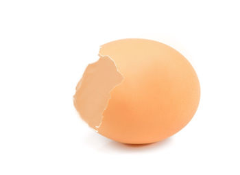 Close-up of broken egg against white background