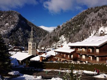 Houses by buildings against sky during winter