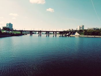 Bridge over sea against sky in city