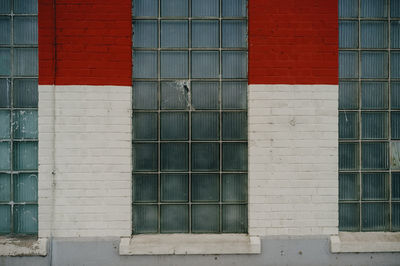 Brick and glass wall with red and white pattern.