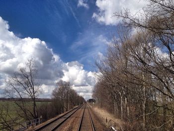 Railroad track against cloudy sky