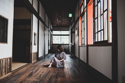 Man sitting in corridor of building