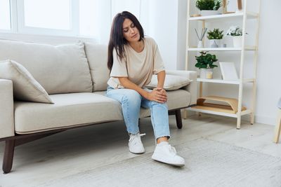 Young woman sitting on sofa at home