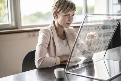 Businesswoman using futuristic modern computer in office