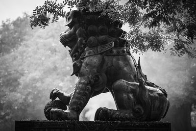 Low angle view of statue against trees