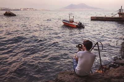 Rear view of people sitting on beach