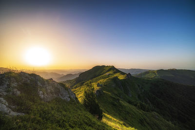 Scenic view of mountains against clear sky during sunset