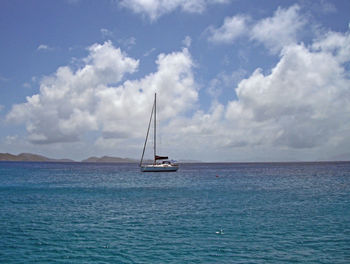 Sailboat sailing on sea against sky