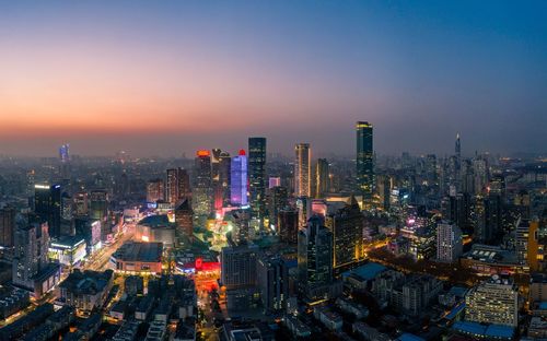 Aerial view of illuminated cityscape against sky at night