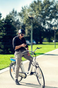 Businessman using mobile phone while sitting on bicycle