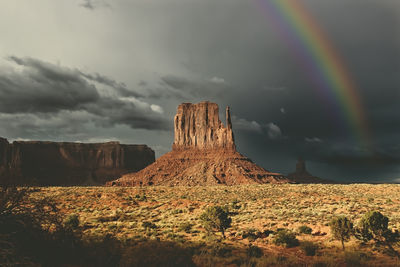 Rainbow over rock formations against sky