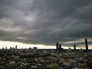 High angle view of buildings in city against cloudy sky