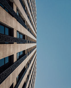 Low angle view of modern building against clear blue sky