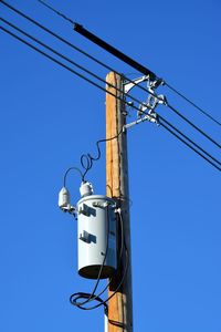 Low angle view of power line against clear blue sky