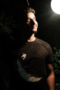 Young man looking at camera at night