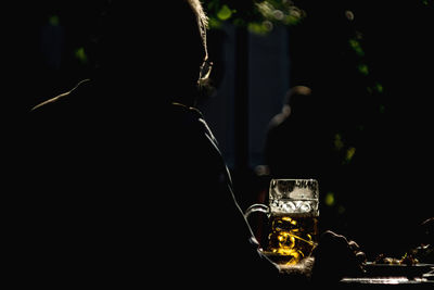 Silhouette man having beer in restaurant at night