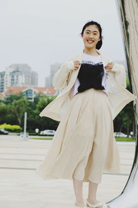 Portrait of young woman standing in city