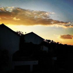 Houses against sky at sunset