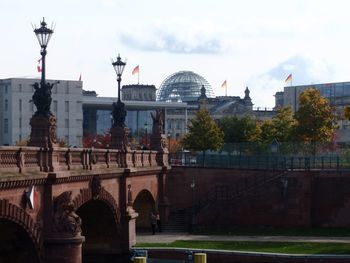 Bridge over river against buildings in city