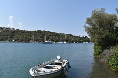 Boats in sea against clear sky