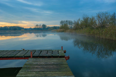 Beautiful view of the misty lake and bridge from planks