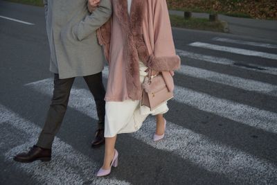 Low section of women standing on road