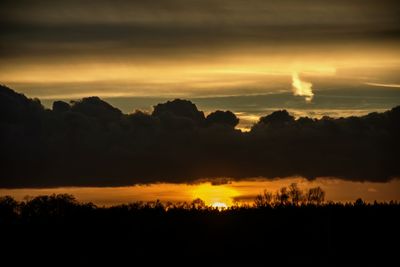 Scenic view of dramatic sky over silhouette landscape