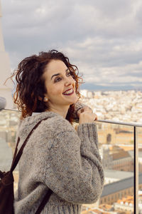 Smiling woman standing against cityscape