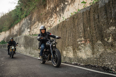 Man riding motor scooter on road