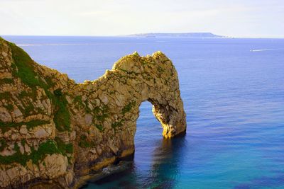 Rock formation in sea against sky