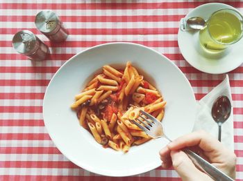 Cropped image of person having pasta served on table