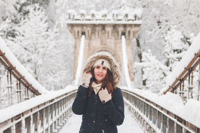 Portrait of smiling young woman standing in snow