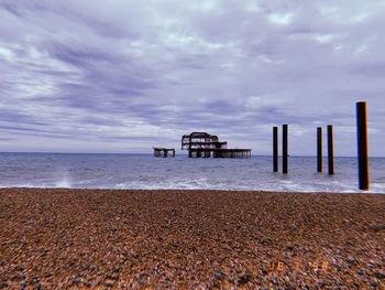 Pier on beach against sky