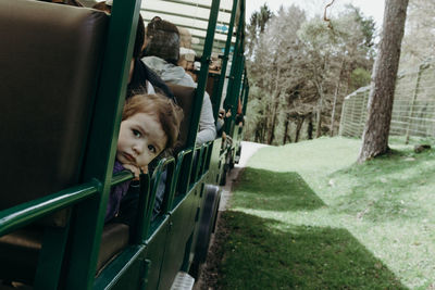 Portrait of a baby girl looking out of a train carriage.
