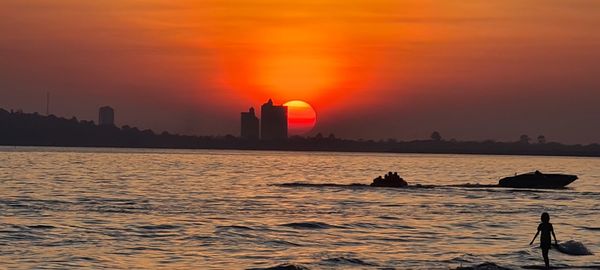 Scenic view of sea against orange sky