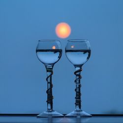Close-up of wine glass on table against blue background